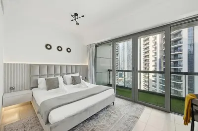 a bedroom with a large bed and large windows at Incredible downtown location in Dubai