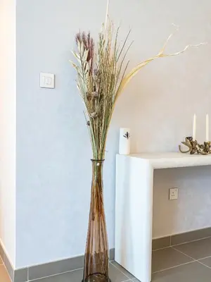 a vase with flowers in it sitting next to a table at Burj Khalifa Bliss I 4 bedroom Apartments I Burj Khalifa & Fountain Views I Free Gym, Pool, Parking, Wi-Fi and PS5 I by Skyline Serenity in Dubai