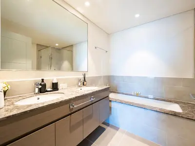 a bathroom with two sinks and a large mirror at Burj Khalifa Bliss I 4 bedroom Apartments I Burj Khalifa & Fountain Views I Free Gym, Pool, Parking, Wi-Fi and PS5 I by Skyline Serenity in Dubai