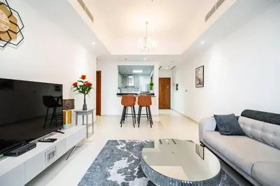 a living room with a couch and a table at Elegant Escapes - Homely 1B in Dunya Tower in Dubai