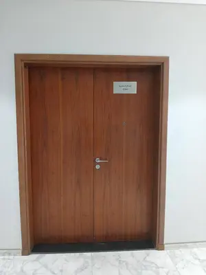 a wooden door in a room with a sign on it at Elegant Escapes - Homely 1B in Dunya Tower in Dubai