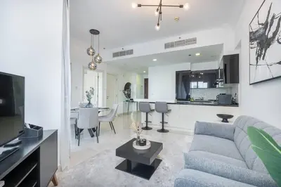 a living room with a blue couch and a kitchen at New Listing & Burj Khalifa View & Dubai Mall in Dubai