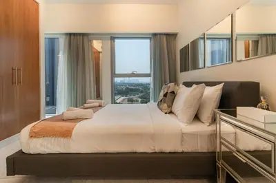 a bedroom with a large bed with a large window at Easy access to Metro - 1BR in Central Park, DIFC - Allsopp&Allsopp in Dubai