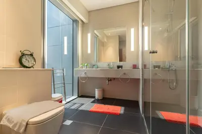 a bathroom with a toilet and a glass shower at Easy access to Metro - 1BR in Central Park, DIFC - Allsopp&Allsopp in Dubai