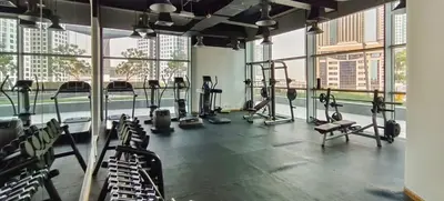 a gym with treadmills and machines in a room with windows at Easy access to Metro - 1BR in Central Park, DIFC - Allsopp&Allsopp in Dubai