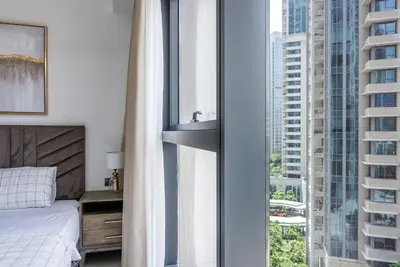 a bedroom with a bed and a large window at Apartment in Downtown Dubai in ACT I ACT II - 5 min walk to Dubai Mall in Dubai