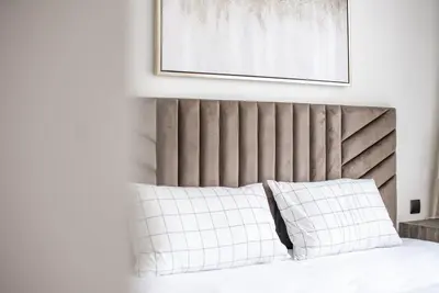 a bed with white pillows and a picture above it at Apartment in Downtown Dubai in ACT I ACT II - 5 min walk to Dubai Mall in Dubai