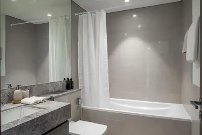a bathroom with a tub and a toilet and a sink at Apartment in Downtown Dubai in ACT I ACT II - 5 min walk to Dubai Mall in Dubai