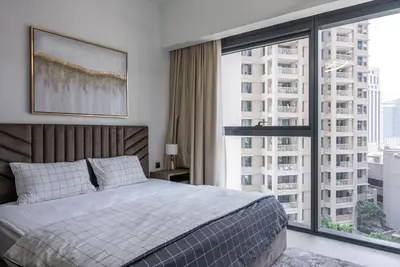 a bedroom with a bed and a large window at Apartment in Downtown Dubai in ACT I ACT II - 5 min walk to Dubai Mall in Dubai
