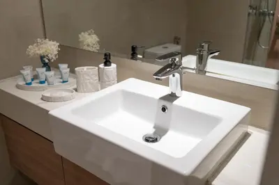 a bathroom with a white sink and a mirror at Pool View & 2 adults 2 kids & Brand New & Czechin in Dubai