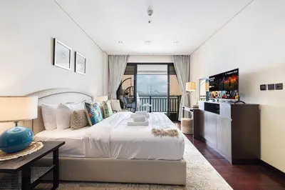 a bedroom with a large bed and a balcony at Beachfront Residences with Full Sea and Burj AlArab Views in Luxury Resort in Dubai