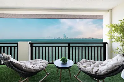 a balcony with two chairs and a table at Beachfront Residences with Full Sea and Burj AlArab Views in Luxury Resort in Dubai