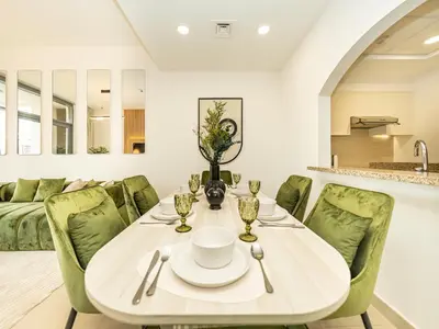 a dining room with a table and green chairs at Stunning Two Bedroom Apartment with Private Balcony & Burj Khalifa by Luxury Space in Dubai