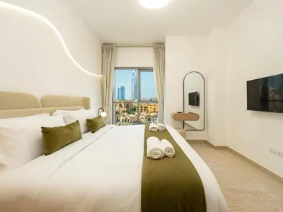 a bedroom with a large white bed with slippers on it at Stunning Two Bedroom Apartment with Private Balcony & Burj Khalifa by Luxury Space in Dubai