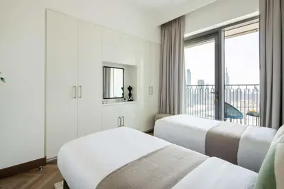 two beds in a hotel room with a balcony at Frank Porter - Downtown Views II Tower 1 in Dubai