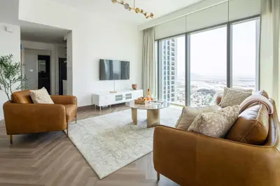 a living room with two chairs and a tv at Frank Porter - Downtown Views II Tower 1 in Dubai