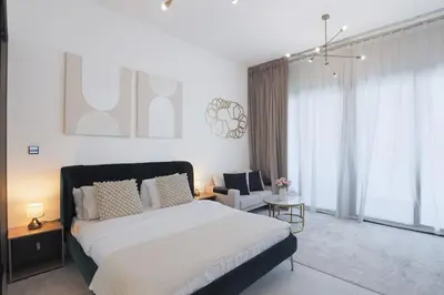a bedroom with a large bed and a chair at Elegant Studio in Binghatti Canal in Dubai