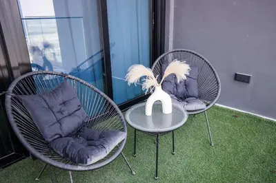 two chairs and a table with a vase on it at Elegant Studio in Binghatti Canal in Dubai