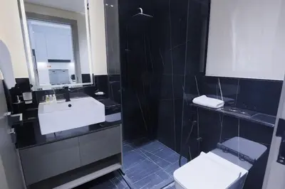 a bathroom with two toilets and a sink and a mirror at Elegant Studio in Binghatti Canal in Dubai