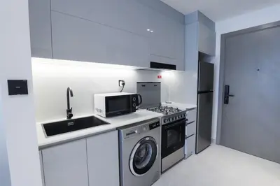 a kitchen with a stove and a sink and a microwave at Elegant Studio in Binghatti Canal in Dubai