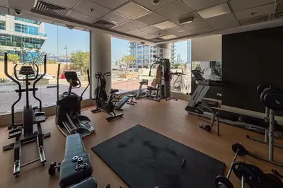 a gym with tread machines and a large window at Frank Porter - Golf Tower 3 in Dubai