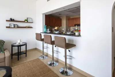 a kitchen with a bar with two stools at Frank Porter - Golf Tower 3 in Dubai