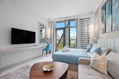 a living room with a couch and a tv at Goldbest - Seven Palm 4ppl in Dubai