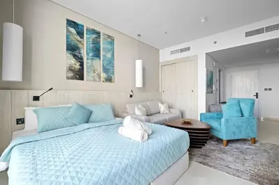 a bedroom with a blue bed and a blue chair at Goldbest - Seven Palm 4ppl in Dubai