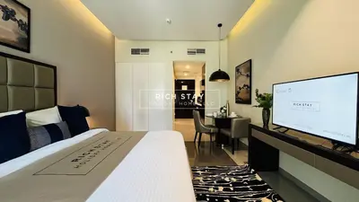 a hotel room with a bed and a flat screen tv at Modern loft Studio in Damac Majestine,Business Bay in Dubai