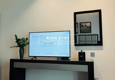 a television sitting on a table with a mirror at Modern loft Studio in Damac Majestine,Business Bay in Dubai