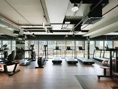 a gym with several treadmills and machines in a room at Trophy - Elevated Living in Luxurious Business Bay Loft in Dubai