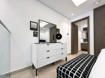 a bedroom with a white dresser and a mirror at Trophy - Elevated Living in Luxurious Business Bay Loft in Dubai