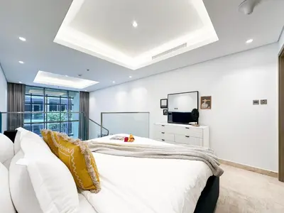 a bedroom with a white bed and a white couch at Trophy - Elevated Living in Luxurious Business Bay Loft in Dubai