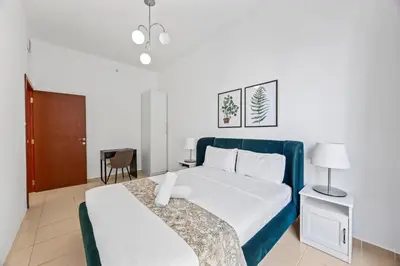 a hotel room with a bed and a chair at Prime Spacious 5 Plus 1 BR Apt On JBR Beach near Metro ,Walk to The Mall, Dining & Entertainment - By Sunkissed Holiday Homes in Dubai