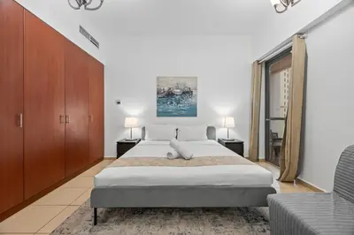 a bedroom with a large bed and a couch at Prime Spacious 5 Plus 1 BR Apt On JBR Beach near Metro ,Walk to The Mall, Dining & Entertainment - By Sunkissed Holiday Homes in Dubai