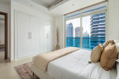 a bedroom with a large bed and a large window at GuestReady - Stunning hideaway in Dubai Marina in Dubai