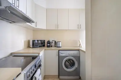 a kitchen with a washing machine and a microwave at GuestReady - Stunning hideaway in Dubai Marina in Dubai