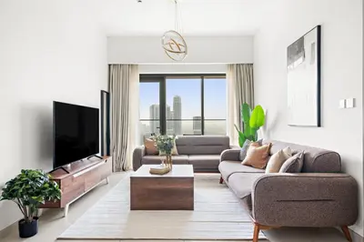 a living room with a couch and a tv at Silkhaus High Floor Luxury 1 BDR with Stunning View in Dubai