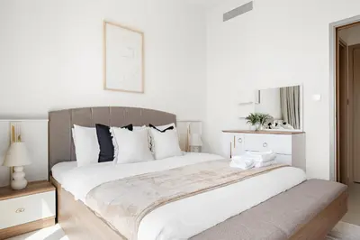 a white bedroom with a large bed with white pillows at Silkhaus High Floor Luxury 1 BDR with Stunning View in Dubai