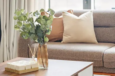 a vase of flowers on a table in front of a couch at Silkhaus High Floor Luxury 1 BDR with Stunning View in Dubai