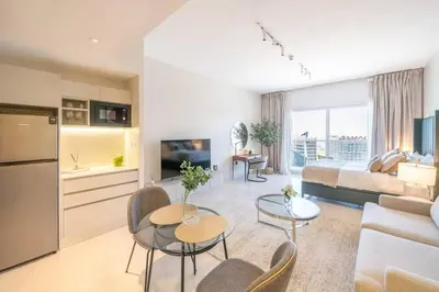 a living room with a couch and a table at Stunning High Floor Studio Apartment in BusinessBay in Dubai