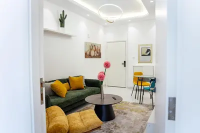 a living room with a green couch and a table at Dubai Marina - 1BHK Modish Apartment in Dubai