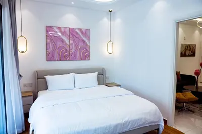 a bedroom with a white bed with a painting on the wall at Dubai Marina - 1BHK Modish Apartment in Dubai