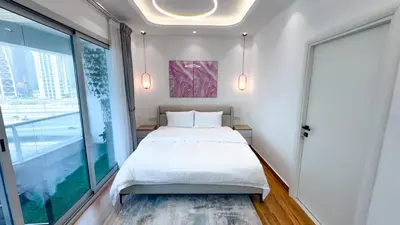 a bedroom with a bed and a large window at Dubai Marina - 1BHK Modish Apartment in Dubai