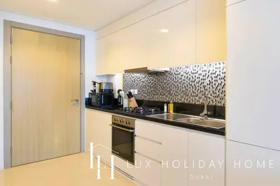 a kitchen with a sink and a stove top oven at LUX The Aykon Suite in Dubai