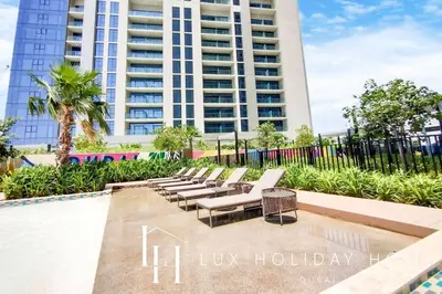 a row of white lounge chairs in front of a building at LUX The Aykon Suite in Dubai