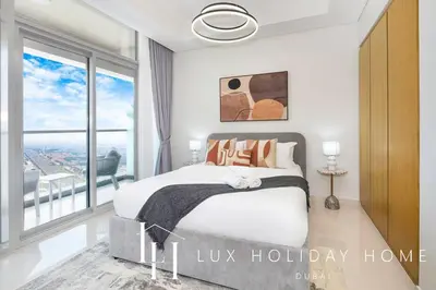 a bedroom with a bed and a large window at LUX The Aykon Suite in Dubai