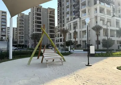 a park with two swings and a bench at Chic 2BD in Dubai Creek Harbour with Infinity Pool in Dubai
