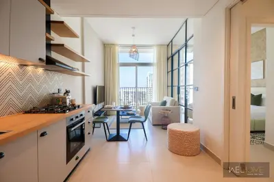 a kitchen with a table and a living room at WelHome - Fancy 1BR Apt at Dubai Hills near Dubai Hills Mall in Dubai