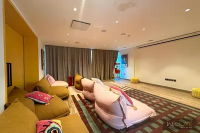 a living room with couches and a large screen at WelHome - Fancy 1BR Apt at Dubai Hills near Dubai Hills Mall in Dubai